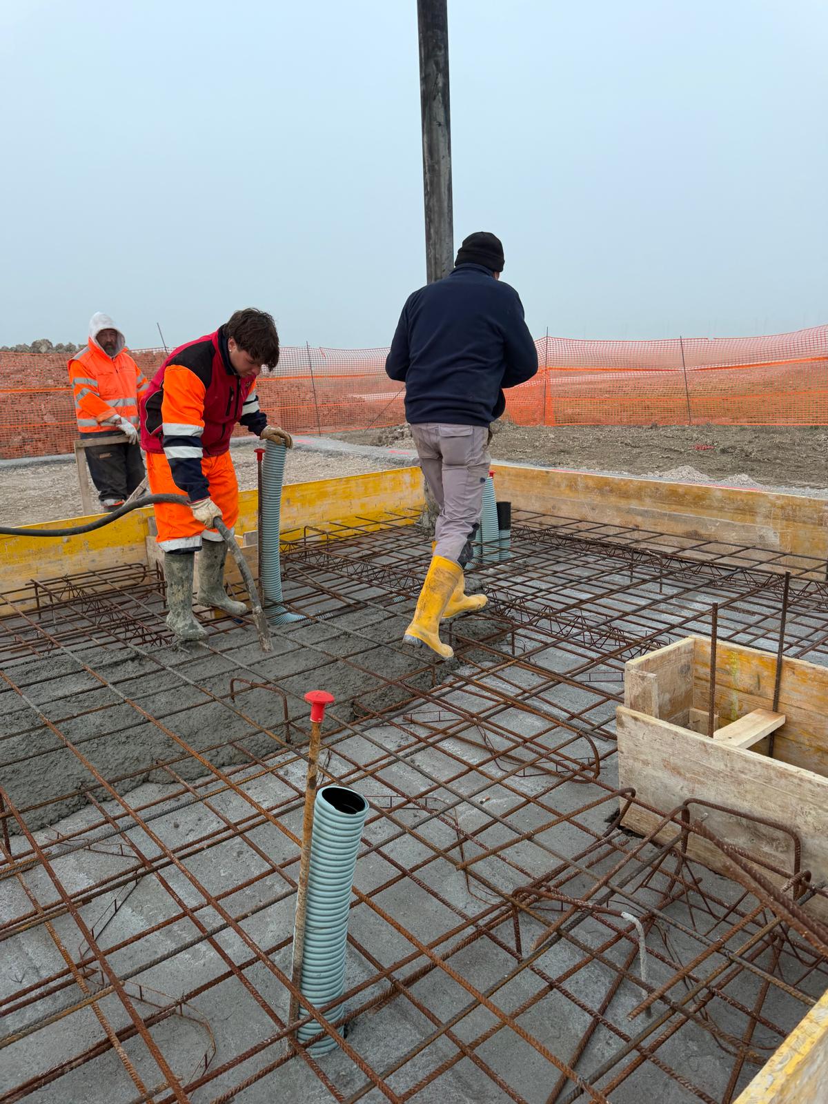 Autobetoniera ed escavatore in un cantiere